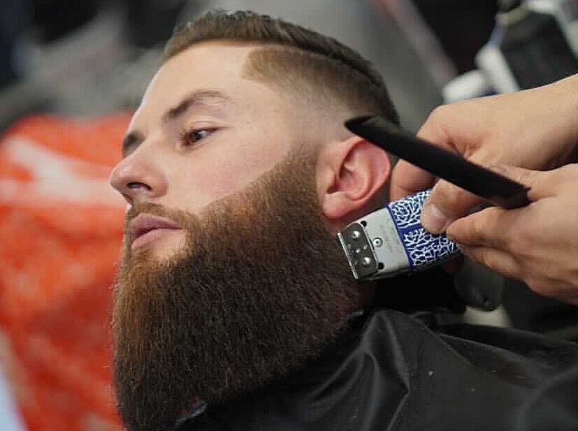 A man receives a beard trim